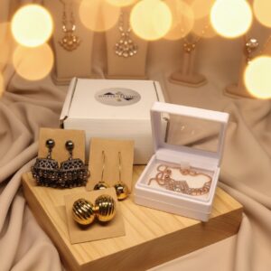 Jewelry gift combo set for women with oxidized jhumka earrings, gold dome studs, gold drop earrings, and rose gold necklace with pearl, displayed with elegant packaging.